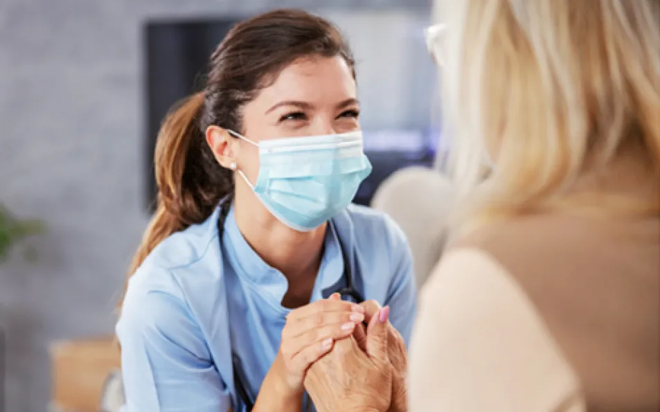 A personal caregiver from Montreal is holding hands of a senior.